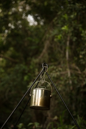 A metal camping pot hanging on a tripod. - Australian Stock Image