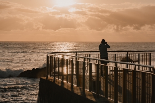 A photographer at the Bronte Ocean Pool (Bronte Baths) at sunrise - Australian Stock Image