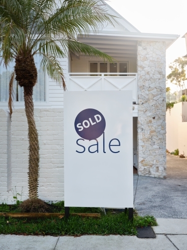 a real estate sign placed outside the house on sale - Australian Stock Image