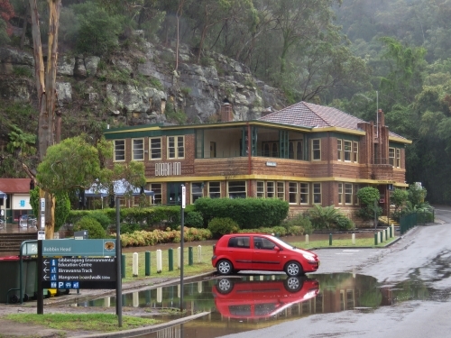 A red car sits in king-tidal water inundation on a misty morning - Australian Stock Image