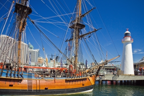 A replica tall ship docked near the lighthouse at Darling Harbor