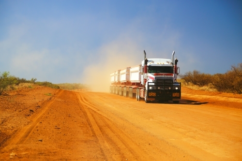 A road train on a dusty road in the Pilbara Region of Western Australia - Australian Stock Image