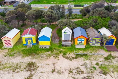 A row of colorful bathing boxes along a bay side beach - Australian Stock Image