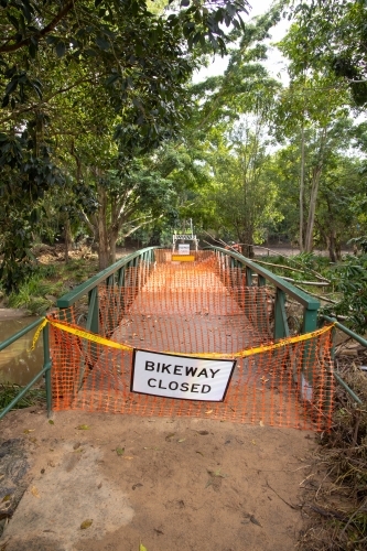 A safety barrier blocks a bridge crossing along a suburban bikeway after a flood event - Australian Stock Image
