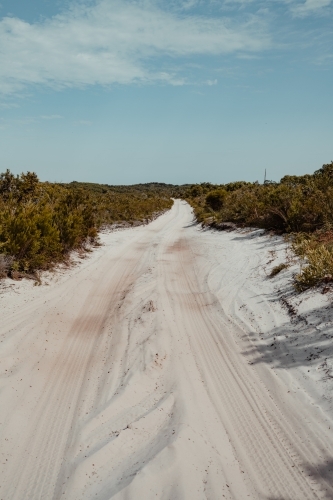 A sandy 4WD track surrounded by coastal vegetation near Honeyeater Lake - Australian Stock Image