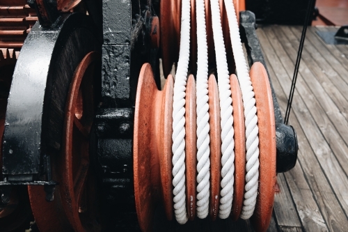 A series of white ropes wound around a large, red wheel or pulley at Old Whaling Station - Australian Stock Image