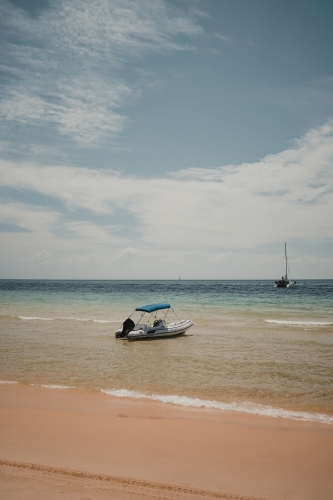 A small boat in the clear blue water near Tangalooma - Australian Stock Image