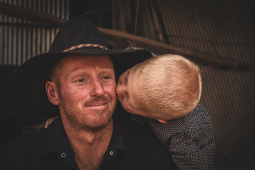 A son giving his father a kiss - Australian Stock Image