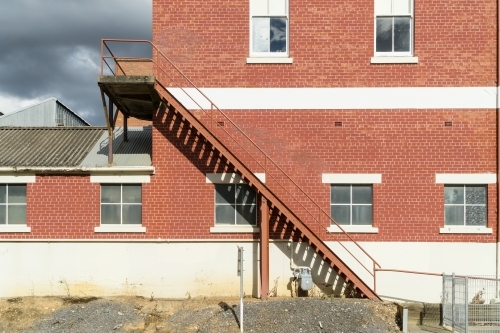 A staircase on the outside of a brick factory wall