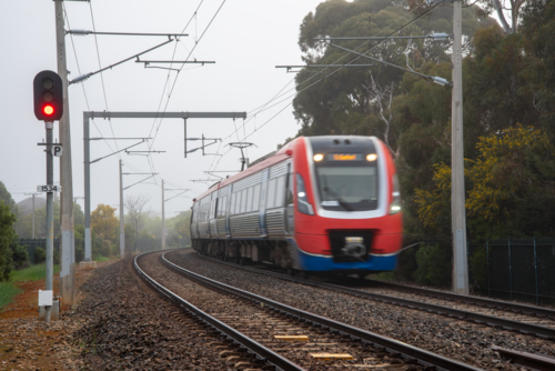 A suburban train on the tracks at Brighton, Adelaide on a foggy day - Australian Stock Image