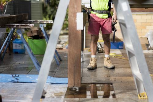 A tradesman standing outside on a home renovation site.