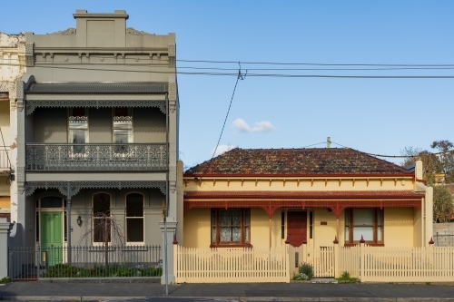 A two storey terrace house alongside an historic cottage in a city street - Australian Stock Image