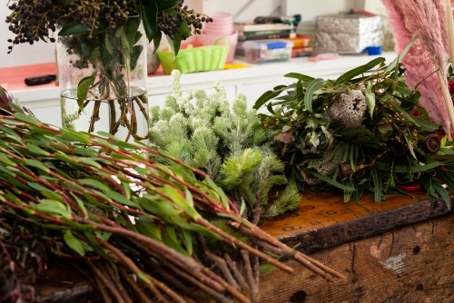 A variety of native and exotic flowers and greenery on a workbench - Australian Stock Image