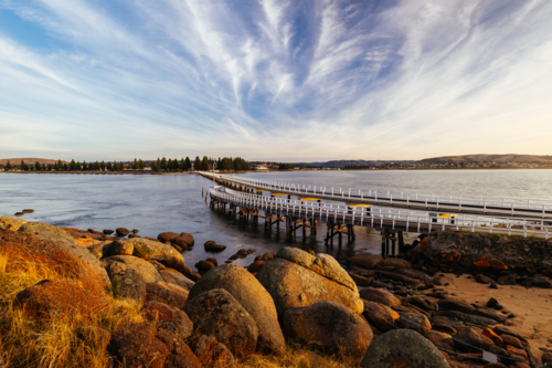 A view of causeway leading to Granite Island Recreation Park at sunrise in Victor Harbor - Australian Stock Image