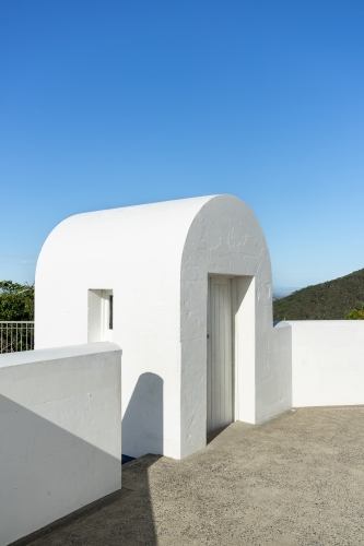 a white curved architectural structure with an open doorway - Australian Stock Image