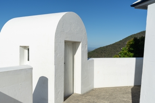 a white curved architectural structure with an open doorway leading to the balcony - Australian Stock Image