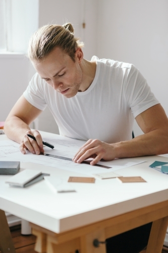 A young creative designer hard at work in a bright office space - Australian Stock Image