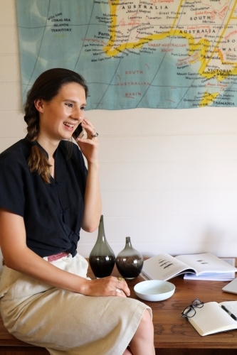 A young creative female worker using her mobile phone - Australian Stock Image