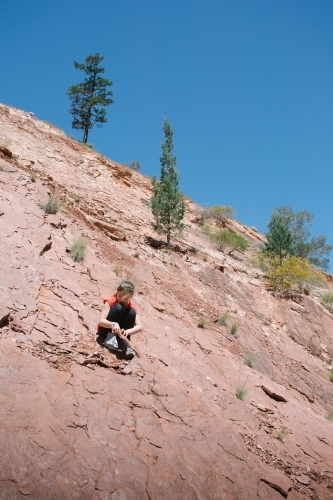 A young girl looking for fossils among rocks - Australian Stock Image
