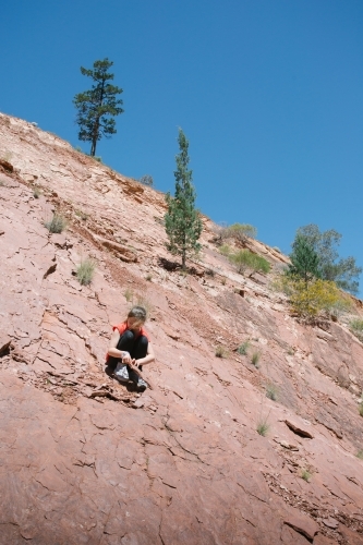 A young girl looking for fossils among rocks