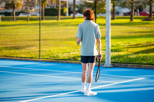 A young male tennis player ready to serve on a tennis match - Australian Stock Image