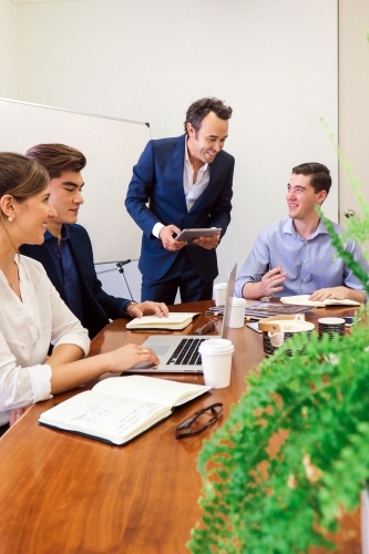 A young team of office workers having a meeting in the board room - Australian Stock Image