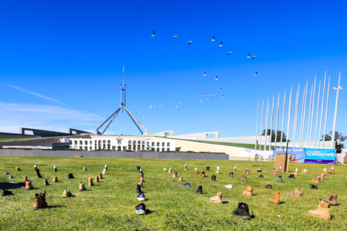 a Zero Suicide Awareness display in Canberra, featuring boots laid out across the lawn - Australian Stock Image