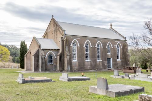 Abandoned grey country church and graveyard - Australian Stock Image