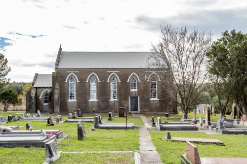 Abandoned grey stone country church and graveyard - Australian Stock Image
