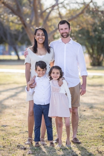 Aboriginal and Caucasian family standing together with twin children - Australian Stock Image