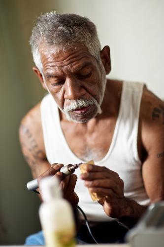 Aboriginal Artist at Work on Message Stick - Australian Stock Image