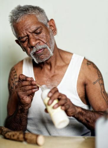 Aboriginal Artist with Glue Bottle - Australian Stock Image