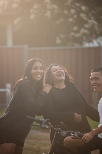 Aboriginal family laughing in backyard - Australian Stock Image