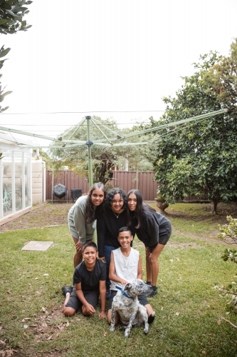 Aboriginal family photo with dog in backyard - Australian Stock Image