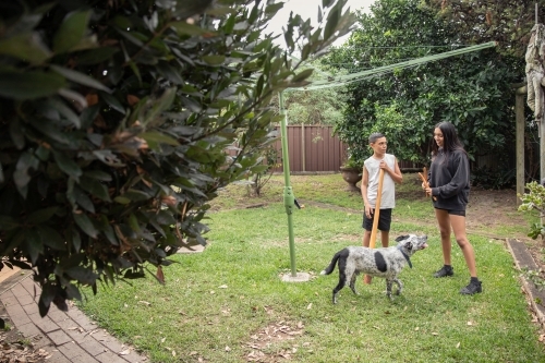Aboriginal family playing instruments in backyard - Australian Stock Image