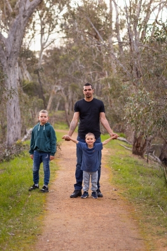 aboriginal father in the bush with his two young kids - Australian Stock Image