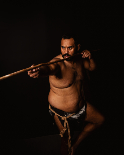 Aboriginal male pointing spear to the side - Australian Stock Image