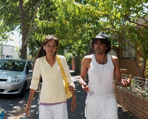 Aboriginal Man and Woman Walking in a Suburban Street - Australian Stock Image