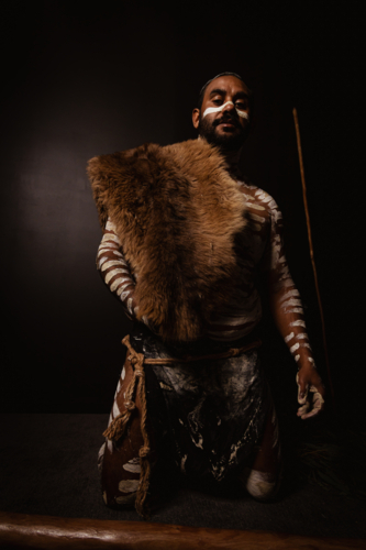 Aboriginal man painted up holding kangaroo skin - Australian Stock Image