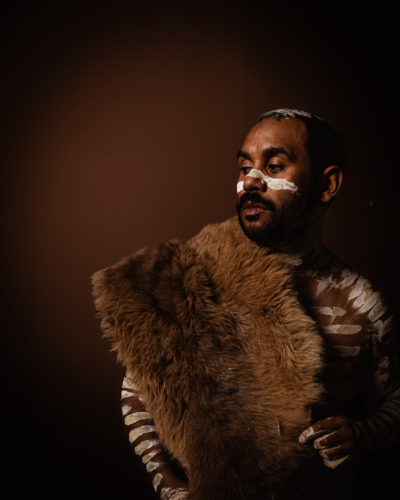 Aboriginal man with kangaroo skin looking to the side - Australian Stock Image