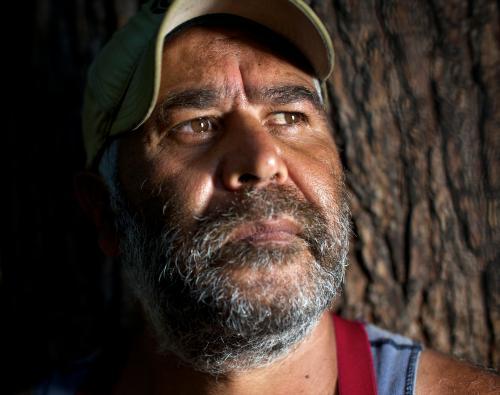 Aboriginal Man with Tree Trunk in Background