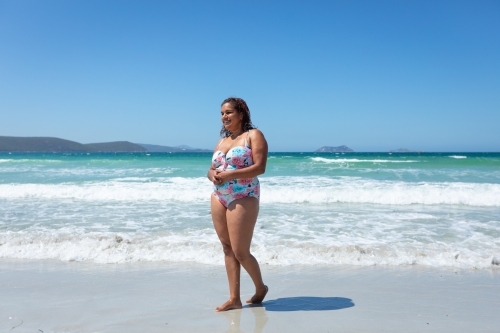 aboriginal woman in bathers on the beach - Australian Stock Image