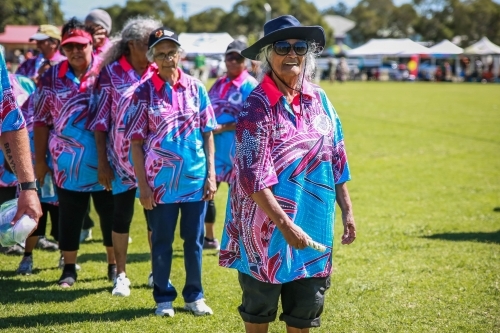 Aboriginal woman standing with team throwing rope ring wearing hat - Australian Stock Image