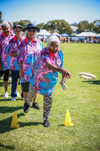 Aboriginal woman throwing rope ring quoits standing between safety cones - Australian Stock Image