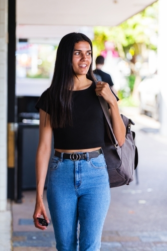 aboriginal woman walking in an urban setting - Australian Stock Image