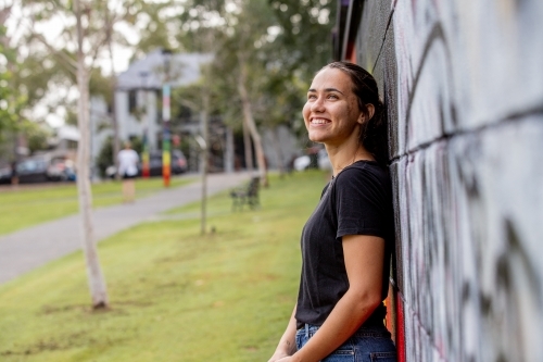 Aboriginal woman wearing a black tshirt smiling and looking out