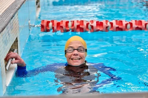 Active senior lady exercising in swimming pool - Australian Stock Image