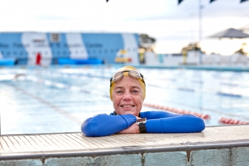Active senior lady exercising in swimming pool - Australian Stock Image