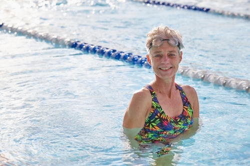 Active senior lady smiling in swimming pool - Australian Stock Image