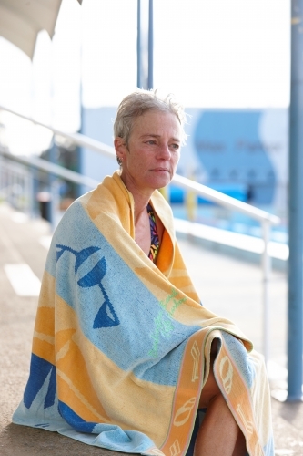 Active senior lady with towel at swimming pool - Australian Stock Image